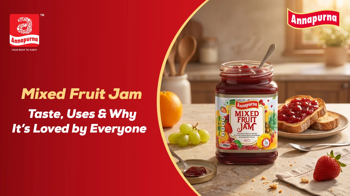 Annapurna Mixed Fruit Jam jar served with jam-covered toast, fresh fruits, and a spoon on a kitchen table